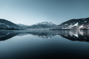 Fototapeta na wymiar Amazing winter vibes at a lake in between snowy mountains in the alps