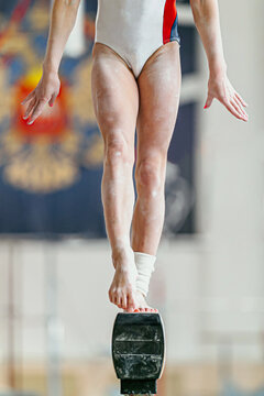 feet girl gymnast on balance beam in gymnastics
