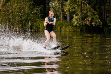 young woman on water skiing riding on lake in summer