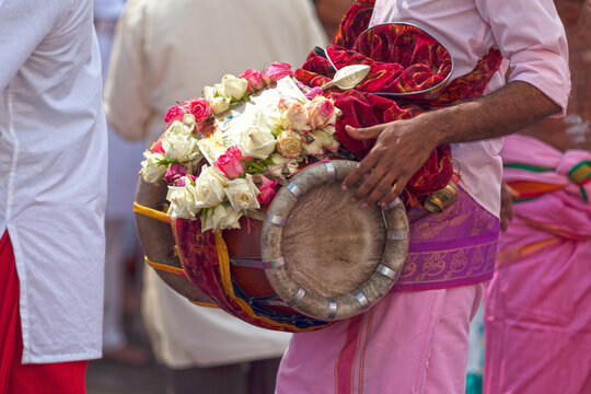 Musician playing with a Thavil during a Tamil procession