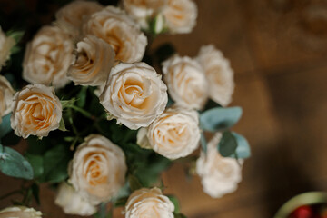 A beautiful bouquet of cream roses on a wooden background. Soft focus.