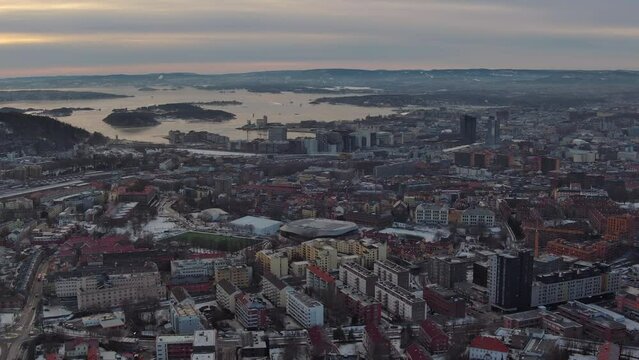 Drone film stock in winter Norway - drone flight over suburds of Oslo city and approaching downtown area - The oslo fjord is visible in the background