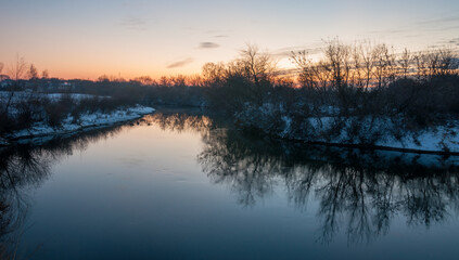 Fototapeta premium Winter enchants with its snow, the crunch of frost that covered villages and cities before sunset.