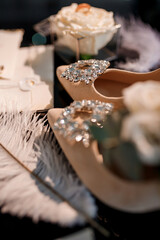 bridal accessories such as shoes, bouquet , ring and perfume lie on a table