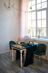 The luxury served table indoors in green colors. Dark wooden table, beautiful evening restaurant with luxury decor