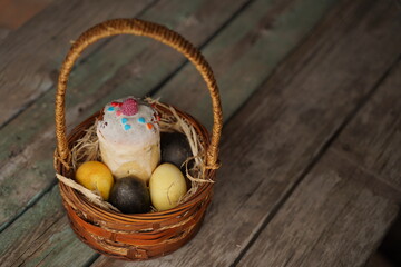 Basket with colorful pastel eggs on kitchen wooden tabletop. Spring easter composition. Space for text or design