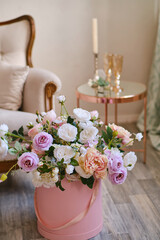 Large bouquet of decorative flowers in a pink hat box in Luxurious interior beautiful classical white interior with white sofa. Spring, flowers, gifts, decorations