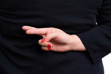 Close-up of businesswoman making bad luck gesture behind back