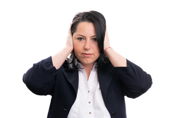 Serious businesswoman covering ears as no hearing gesture