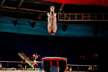 female gymnast athlete exercise gymnastics vault in competition - obrazy, fototapety, plakaty