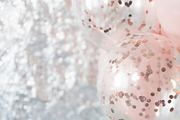 Pastel pink and transparent balloons on silver foil background