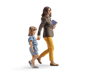 Full length profile shot of a woman walking carrying books and holding hands with a little girl - Powered by Adobe