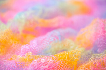 Knitted surface woolen items rainbow colored as a background. Closeup of soft multicolored knitted texture patterns. Warm winter clothes. Background textile surface with copy space for text. blurred