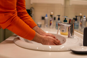 Fototapeta na wymiar Global Handwashing Day Concept. Washing hands with soap under the water tap with water in bathroom.