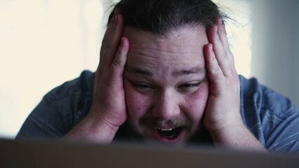 One excited fat man celebrates success in front of computer. close up male person face feeling happy. WOW winner emotion