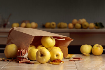 Fresh juicy apples in in paper bag and cinnamon sticks.