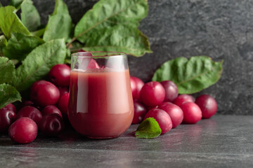 Red plums and a glass of plum juice.