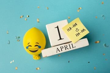 April 1st. Image of april 1 wooden calendar and festive decor on the blue background. April Fool's...
