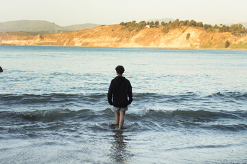 young man by the sea at sunset