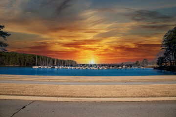 Boats and yachts docked in the marina on Lake Lanier with lush green trees and powerful clouds at sunset in Gainesville Georgia USA