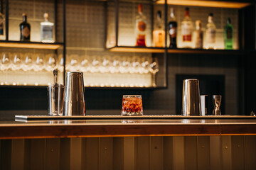  glass of aperol syringe stands on the bar counter, the bar is in the background