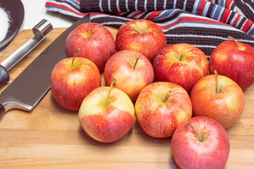 A group of apples on a cutting board ready to be cored and cubed to make a dessert.