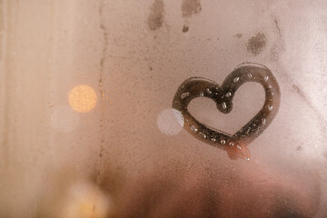 A heart painted on a misted window. Heart on misted glass. Heart on a window background. Heart...