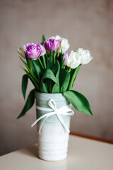A bouquet of purple and white tulips in a vase.