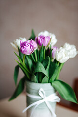 Obraz premium A bouquet of purple and white tulips in a vase.