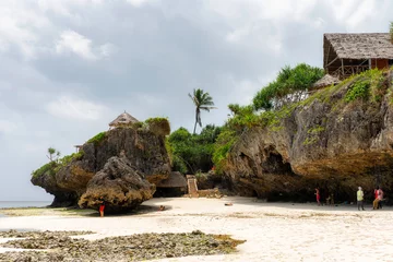 Photo sur Plexiglas Zanzibar Sunny vacation at Mtende Beach, Zanzibar, surrounded by rocks for a peaceful retreat