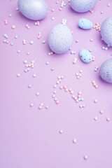 Bunch of colorful eggs with dots on purple background. Minimal Easter concept with copy space for text.
