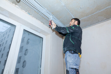 Electrical worker checks voltage in wires. Repair in new apartment, electricity wiring. High quality photo