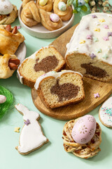 Festive dinner, Easter brunch. Happy Easter holiday food baking puff pastry and cupcake with Easter Bunny on pastel green background.