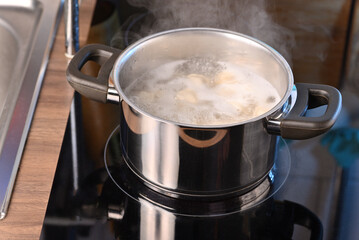 Dumplings in a saucepan on the electric stove.