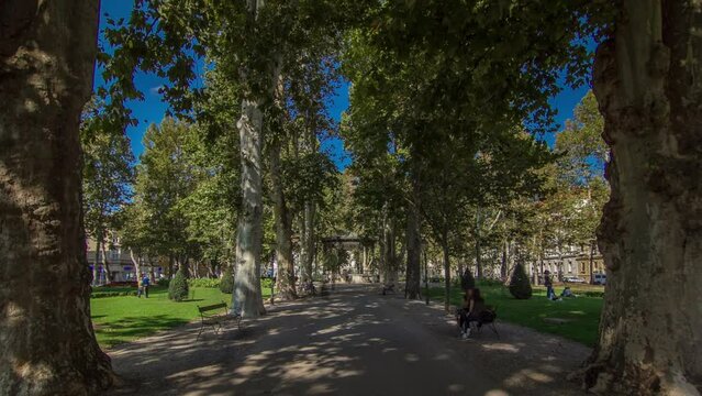 People walking around pavillion in Zrinjevac park timelapse hyperlapse in Zagreb, Croatia. Zrinjevac is spread over 12540 sq meters in city center. People relaxing on a bench