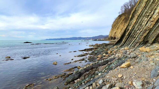 Sea waves on the Black Sea coast. Waves splash on the beach with pebbles in the rays of the sun. Sunset on the Black Sea. Panoramic view of the Black Sea. Kiseleva Rock, Russia, Agoi