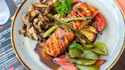 a close up birds eye view of freshly grilled Canadian Salmon in teriyaki sauce served with grilled vegetables  