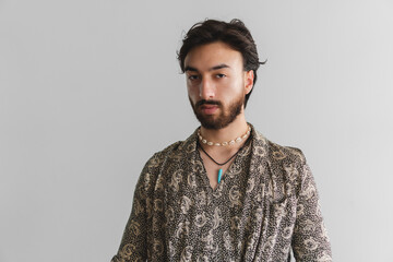 Serious young gay latin queer man looking at camera on a white background. Copy space.