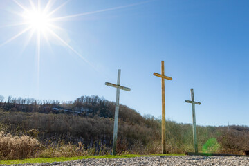 Sunlight on three wooden crosses on hill