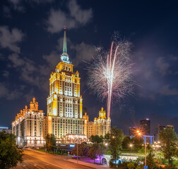 Illuminated high-rise stalinist building at summer night and fireworks in the night sky in Moscow ,...