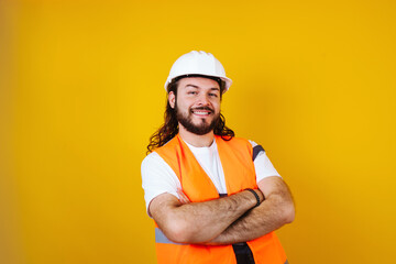 portrait of Hispanic bearded young man engineering and worker with hard helmet in Mexico Latin America on blue background	