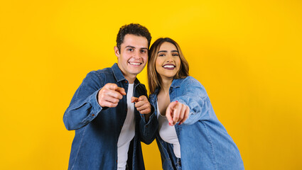 young hispanic couple portrait having fun on yellow background in Mexico Latin America - obrazy, fototapety, plakaty
