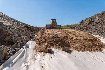 the process of leveling sand with a modern bulldozer during the construction of a dirt road