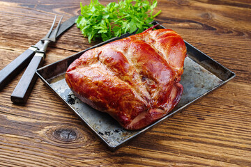 Traditionell gepökeltes und geräuchertes badisches Schäufele von der Schweineschulter serviert geschmort mit Petersilie als close-up auf einem rustikalen Metall Tablett 