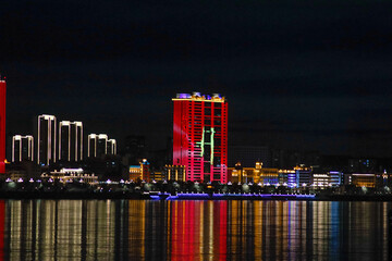 View of the Chinese city at night. Neon illumination of houses on the Amur River.