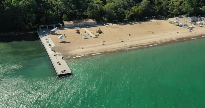 Large suburban public beach in Glencoe, Illinois with long pier along the Lake Michigan shoreline with sailboats and kayaks.