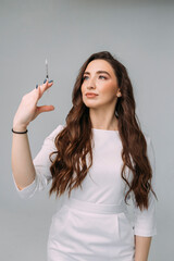 young woman doctor in a white coat holds an insulin syringe in her hand. Girl cosmetologist preparing to make an injection of botulinum toxin in a cosmetology clinic