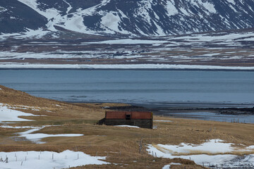 A small cabin in a meadow in front of the Atlantic Ocean in the north of Iceland in front of a mountain called Kirkjufell.