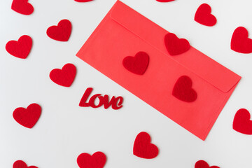 A love letter, the inscription of love on a red paper envelope on the background of small red hearts. The concept of St. Valentine's Day.