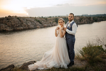 Fototapeta na wymiar bride blonde girl and groom near the river